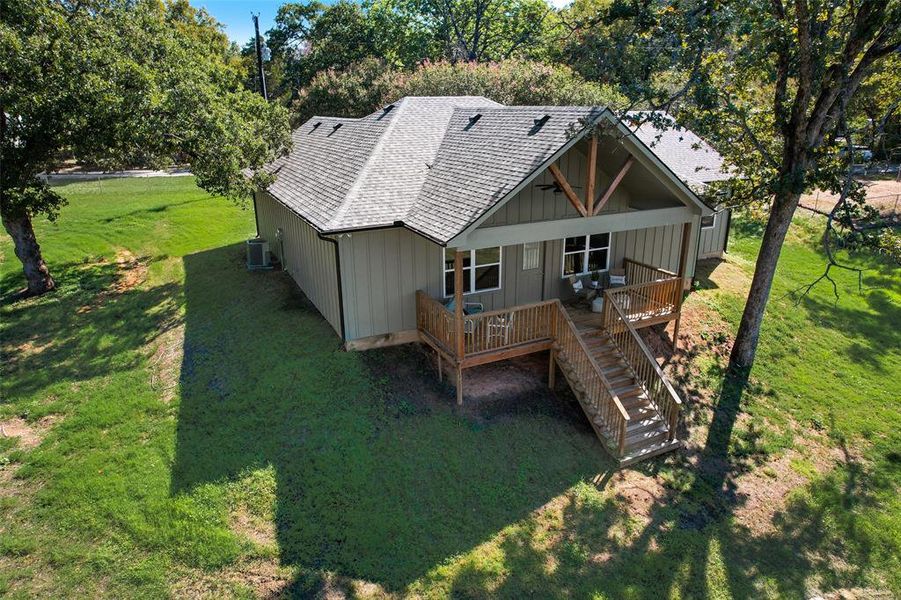 Rear view of property with a yard, central AC, and a wooden deck