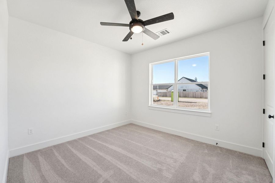 Unfurnished room with light colored carpet and ceiling fan