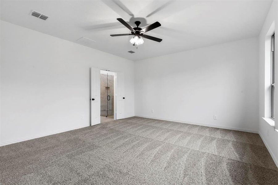 Carpeted spare room featuring ceiling fan