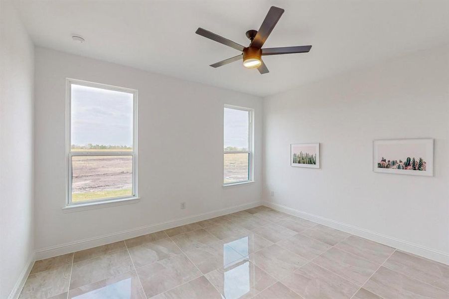 Unfurnished room featuring ceiling fan and light tile patterned floors