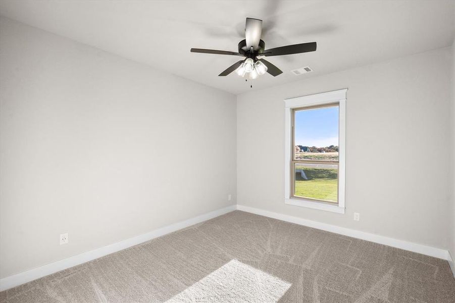 Empty room featuring carpet flooring and ceiling fan