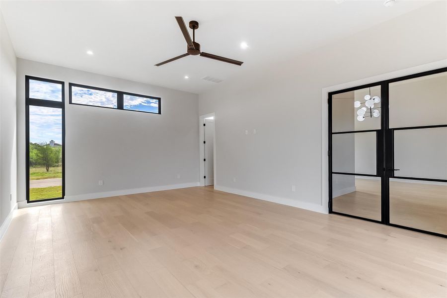 Empty room with ceiling fan, light wood-style flooring, baseboards, and recessed lighting Empty room with ceiling fan, light wood-style flooring, baseboards, and recessed lighting