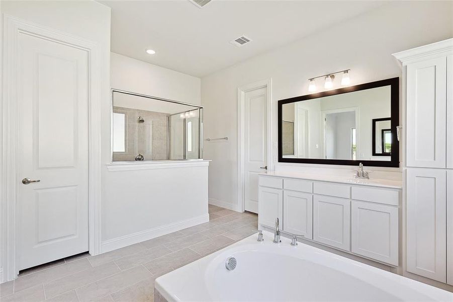 Bathroom with tile patterned flooring, independent shower and bath, and vanity