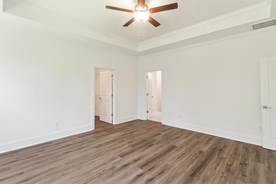 Gleaming LVP floors run through a bedroom featurin