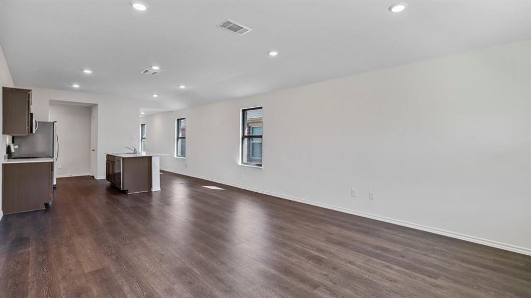 Kitchen with a center island with sink, open floor plan, dark wood-style flooring, dark wood finish cabinets, and recessed lighting Kitchen with a center island with sink, open floor plan, dark wood-style flooring, dark wood finish cabinets, and recessed lighting