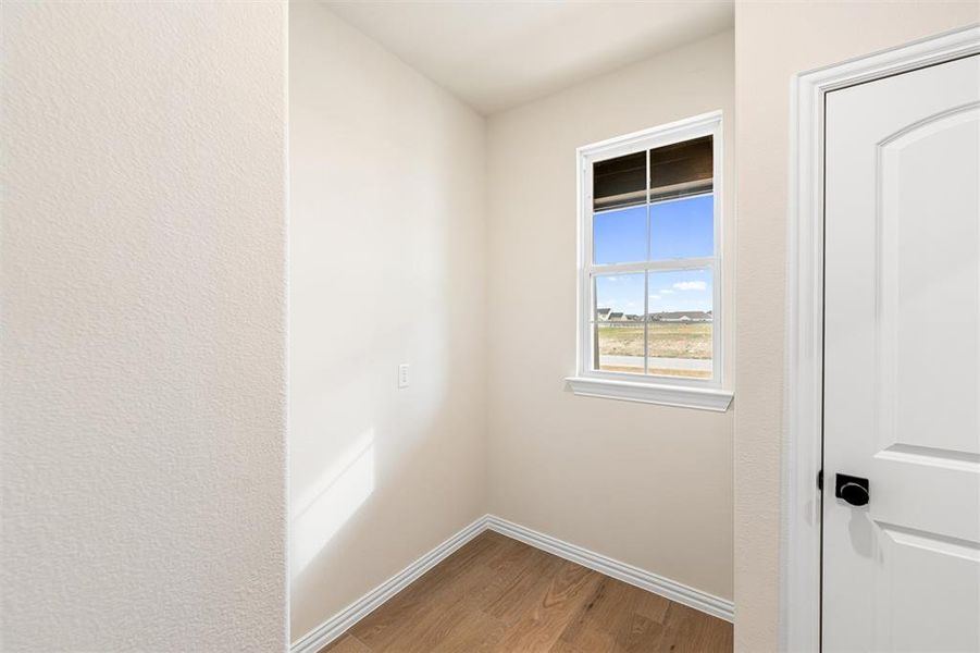 Unfurnished room featuring light wood-type flooring and a textured wall