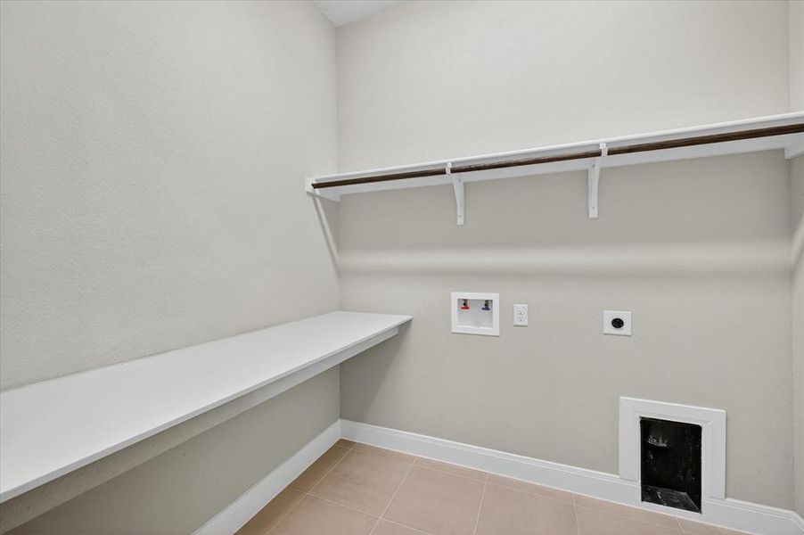Laundry room with light-toned walls and tile flooring Laundry room with light-toned walls and tile flooring