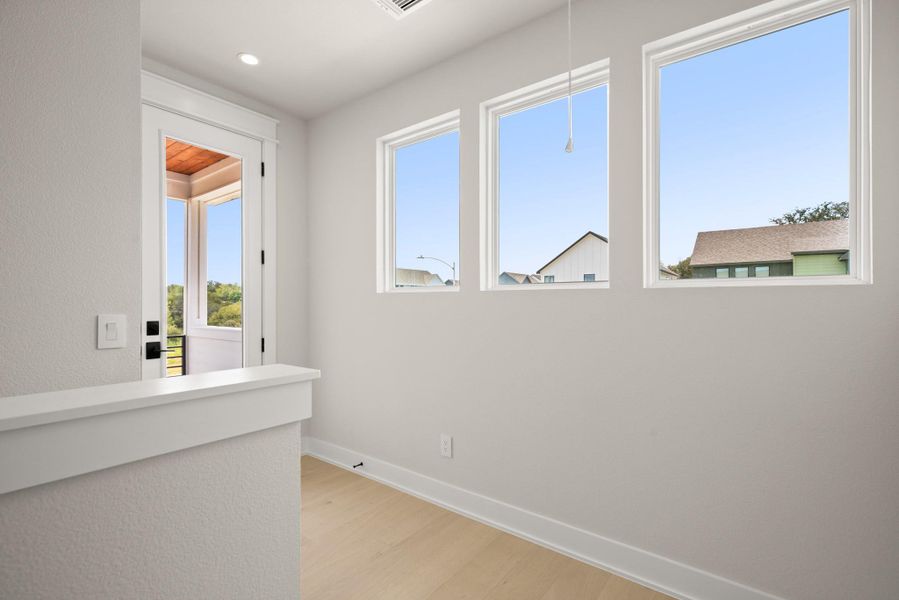 Hall with light wood-type flooring and recessed lighting