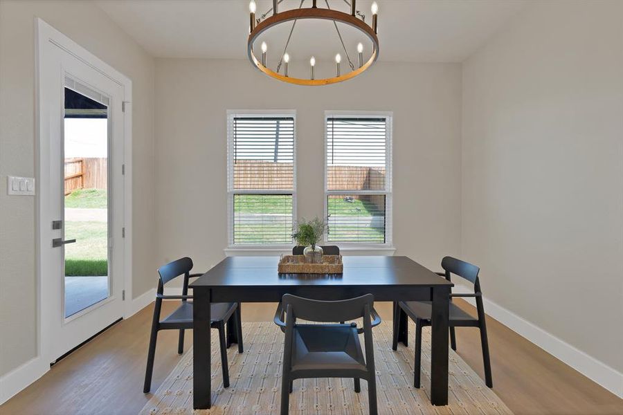 Dining area with plenty of natural light, a chandelier, and wood finished floors