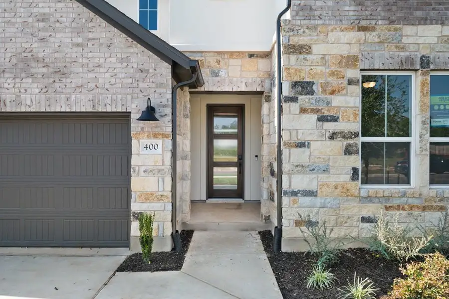 Front exterior of a new home in Park Collection At Wolf Ranch, Georgetown, TX, highlighting curb appeal (Image 2).