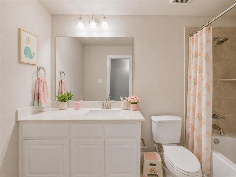 Vanity area featuring a built-in sink, stainless steel faucet, and a large wall-mounted mirror