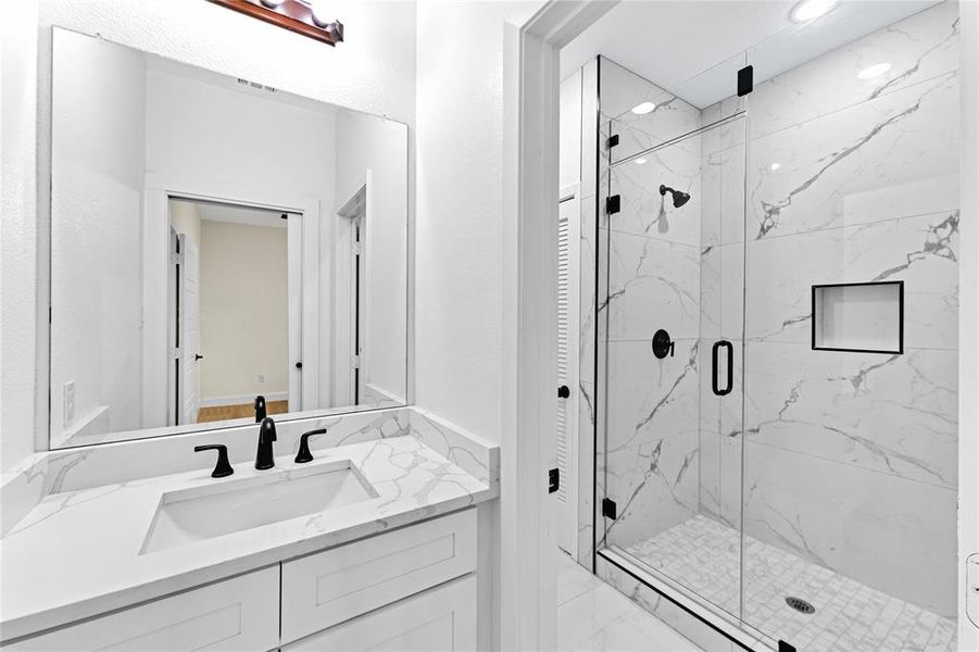 Bathroom with vanity and a shower with door