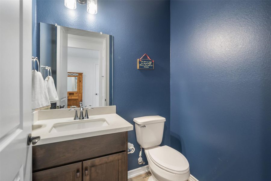 Convenient half bath for guests is located in a hallway by the front extra bedroom.