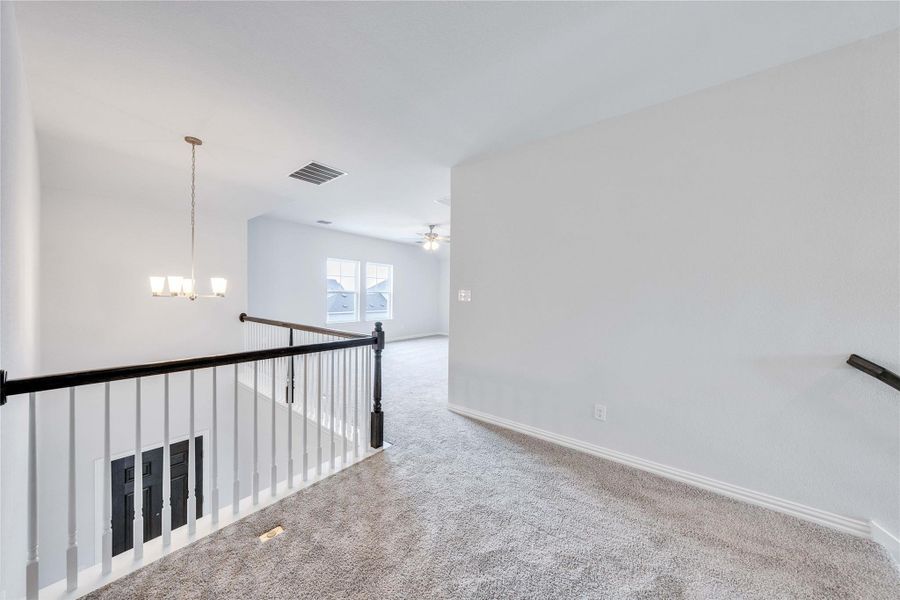 Unfurnished room featuring carpet flooring, a chandelier, baseboards, and ceiling fan Unfurnished room featuring carpet flooring, a chandelier, baseboards, and ceiling fan