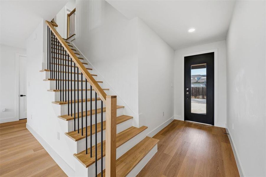 Foyer features recessed lighting. Black front door
with glass panel provides natural light into the
space. Wood staircase with black metal balusters
serves as a focal point. Vinyl flooring extends
throughout.