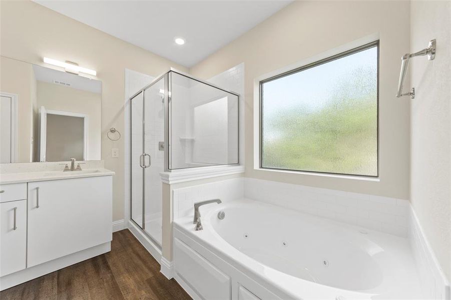 Bathroom with vanity, plus walk in shower, and wood-type flooring