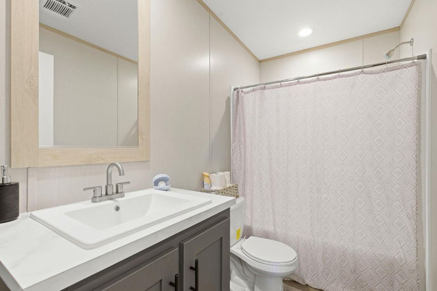 Full bathroom with vanity and crown molding