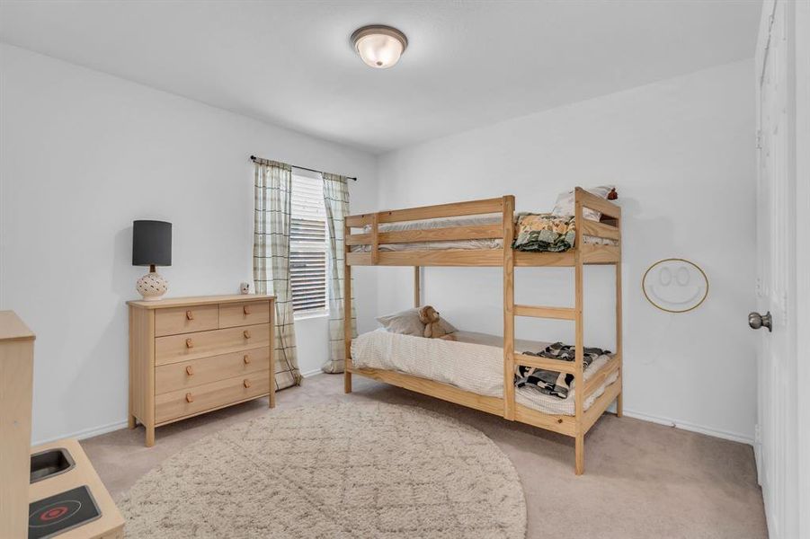 Bedroom featuring light carpet and baseboards