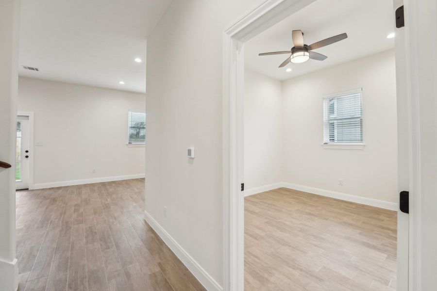Hall with recessed lighting, wood plank tile floor, visible vents, and baseboards Hall with recessed lighting, wood plank tile floor, visible vents, and baseboards