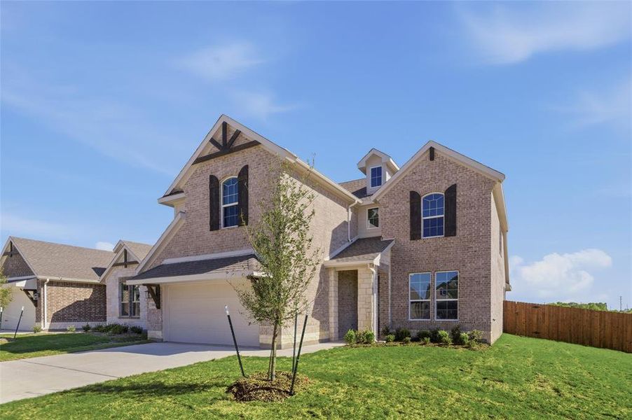 Traditional home featuring brick siding, concrete driveway, and a garage