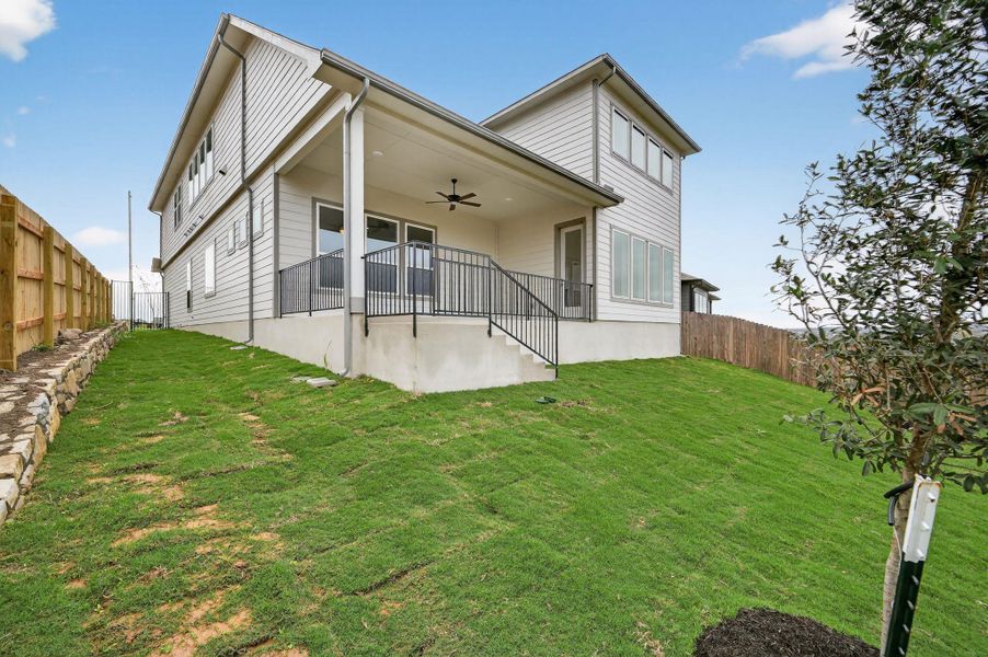 Rear view of house with ceiling fan, a fenced backyard, and a patio area