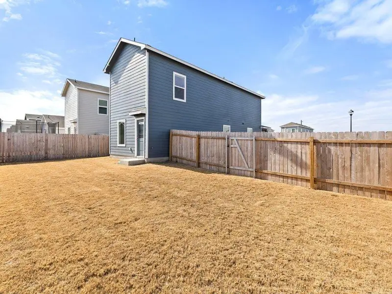 Back of house with a fenced backyard