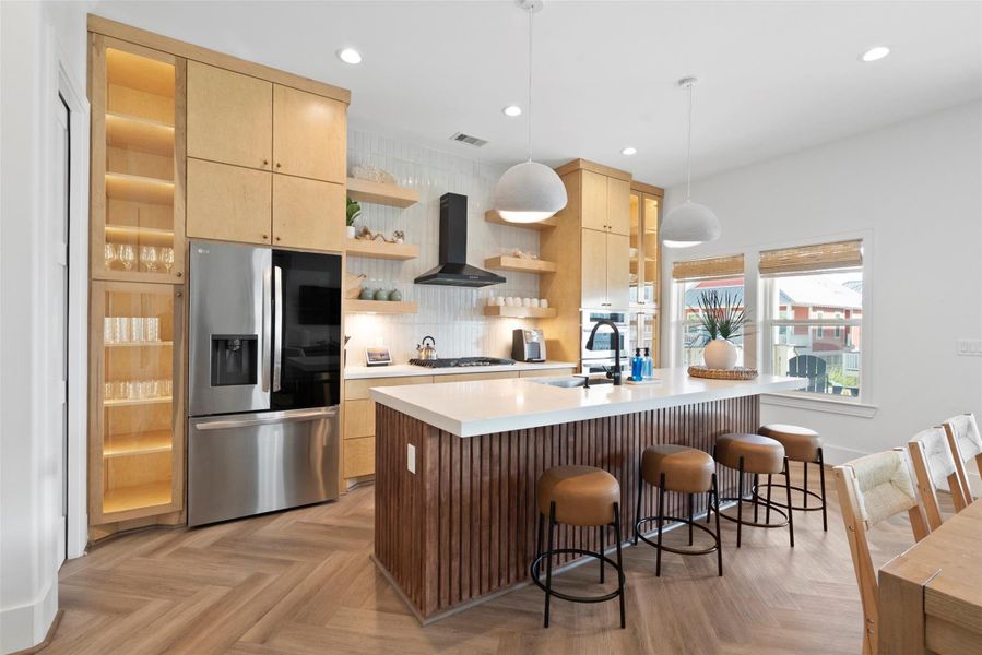 This modern coastal kitchen blends style and function with a spacious island that includes a built-in sink and casual seating. A sleek, stainless steel French door refrigerator with an ice maker and bottom freezer adds modern convenience, while the warm wood tones and clean lines maintain a breezy, relaxed vibe. This modern coastal kitchen blends style and function with a spacious island that includes a built-in sink and casual seating. A sleek, stainless steel French door refrigerator with an ice maker and bottom freezer adds modern convenience, while the warm wood tones and clean lines maintain a breezy, relaxed vibe.