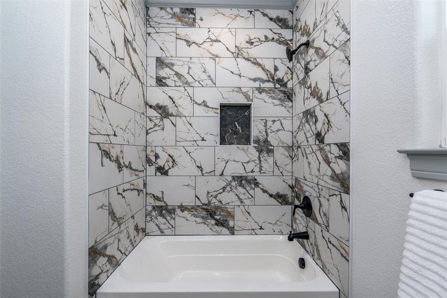 Designer spa like tile in full bath.