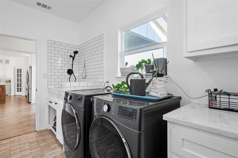 Washroom featuring cabinet space and separate washer and dryer