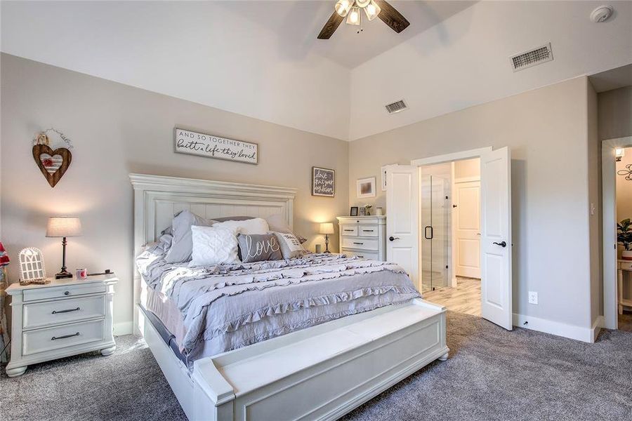 Bedroom with carpet flooring, ceiling fan, and vaulted ceiling