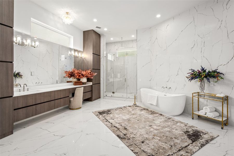 With a footprint rivaling that of the bedroom, the primary bathroom offers an impressive sense of space and serenity. Polished porcelain floors set the stage for two expansive vanities with generous storage, a six-foot freestanding soaking tub, and an oversized walk-in shower featuring multiple body sprays, rain shower & dual showerheads. Polished nickel hardware and a pair of designer glass light fixtures add a refined, spa-like touch. With a footprint rivaling that of the bedroom, the primary bathroom offers an impressive sense of space and serenity. Polished porcelain floors set the stage for two expansive vanities with generous storage, a six-foot freestanding soaking tub, and an oversized walk-in shower featuring multiple body sprays, rain shower & dual showerheads. Polished nickel hardware and a pair of designer glass light fixtures add a refined, spa-like touch.