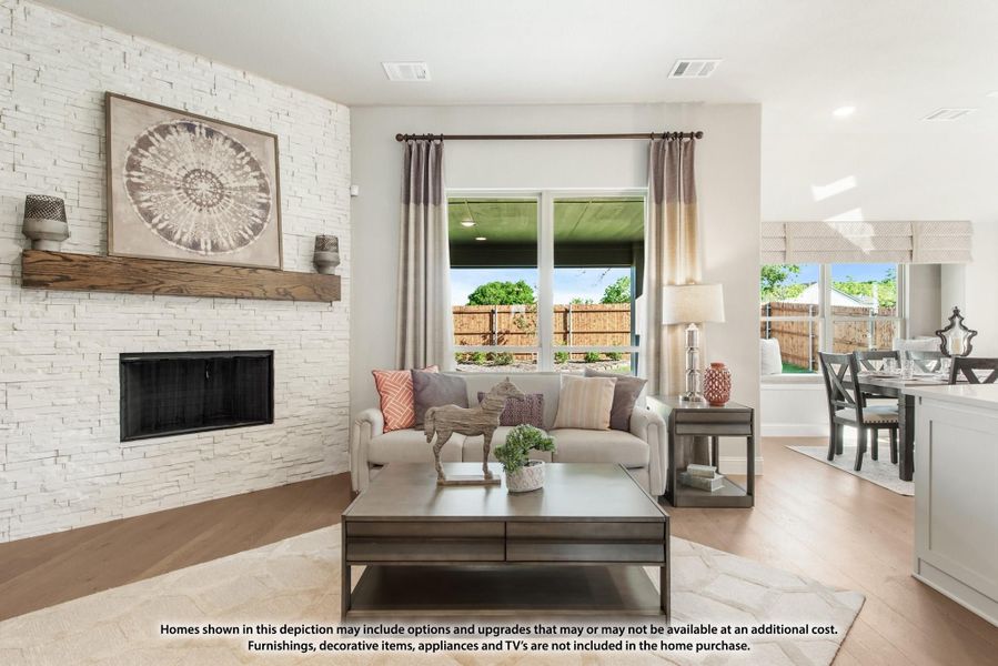 Living room with white stacked stone fireplace, wood mantel, sofa, and hardwood floors