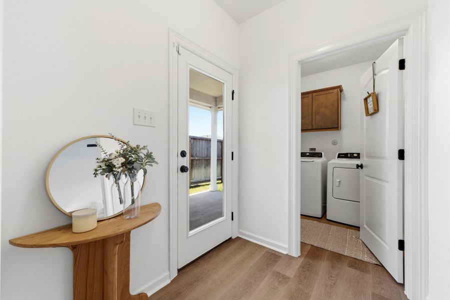 Functional mudroom with a dedicated laundry room, included washer and dryer, and direct access to the covered patio.