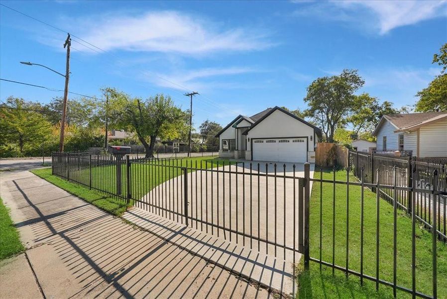 View of front of home featuring a fenced front yard, driveway, and a garage