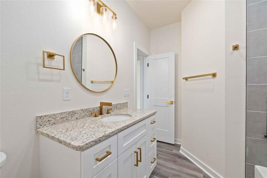 Full bathroom with vanity and dark wood-style flooring Full bathroom with vanity and dark wood-style flooring