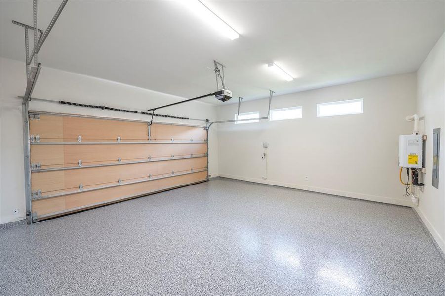 Garage featuring a garage door opener and water heater