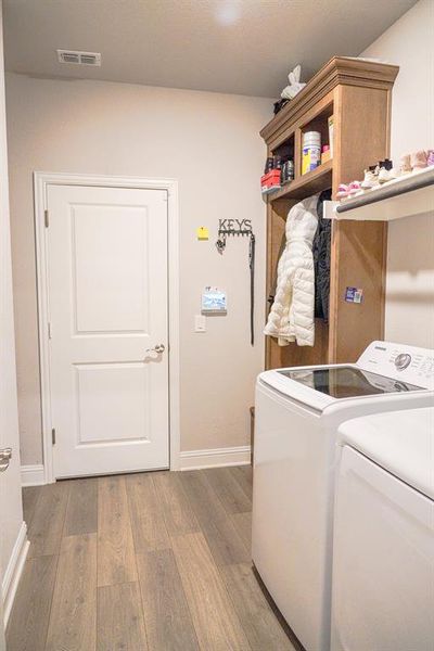 Laundry area featuring light wood-style floors and washer and dryer