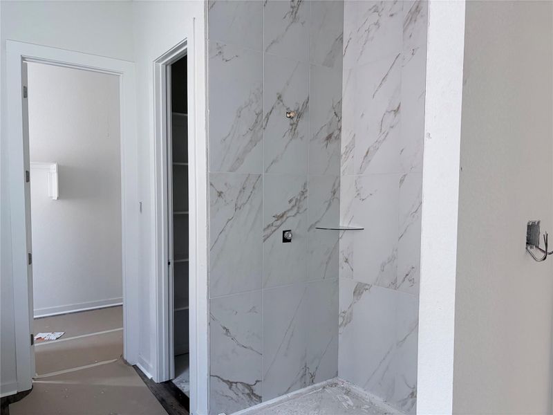 A clean, newly tiled shower area awaits finishing touches. A clean, newly tiled shower area awaits finishing touches.