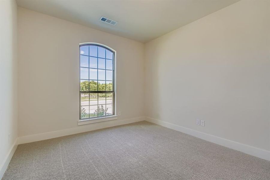 Empty room with light colored carpet and baseboards