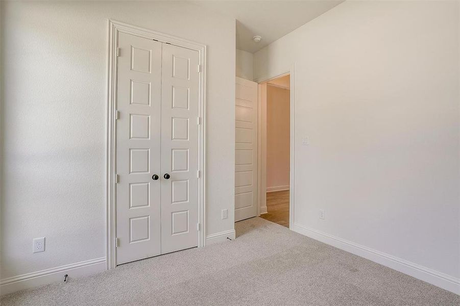 Unfurnished bedroom with light colored carpet and a closet