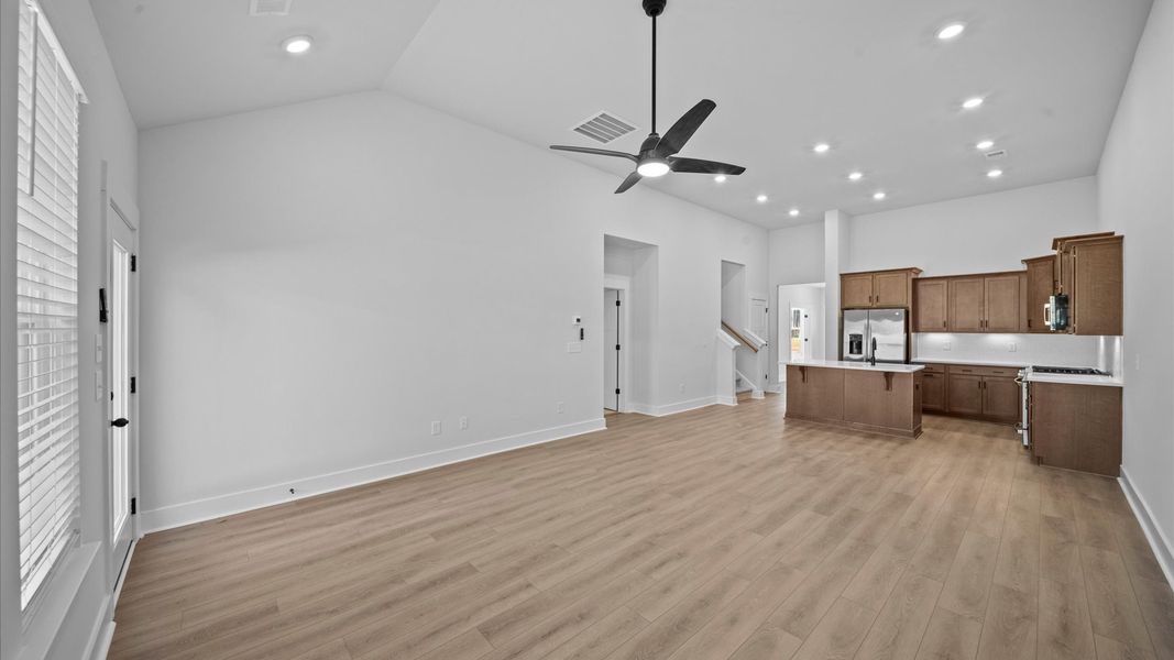 Vibrant family room with high-impact two-story ceilings and thoughtful layout for entertaining
