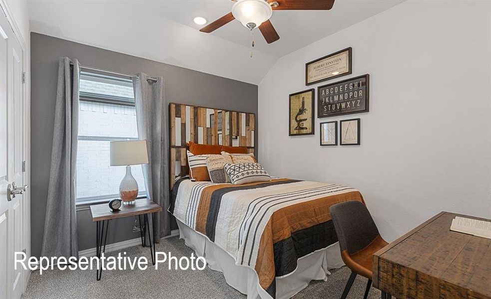 Carpeted bedroom with ceiling fan and vaulted ceiling