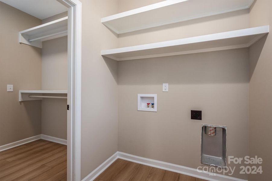 Laundry on the main with wood shelving.