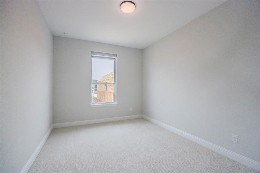 Unfurnished room with light colored carpet and baseboards