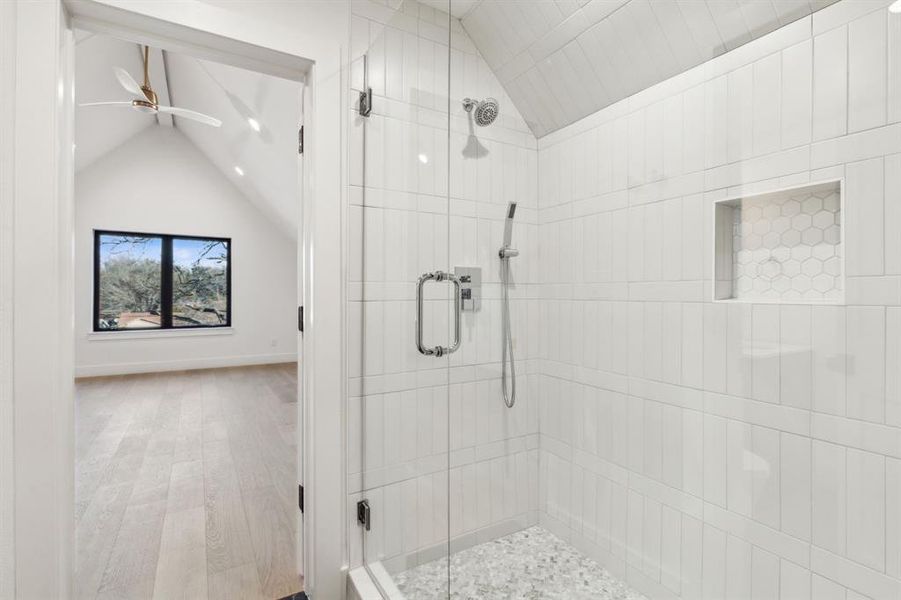 Secondary bathroom with glass-enclosed shower and adjacent walk-in closet, offering functional storage and clean, modern finishes.