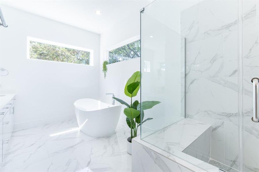 Elegant 6' floating tub and freestanding shower with bench seat and Hans Grohe plumbing fixtures.