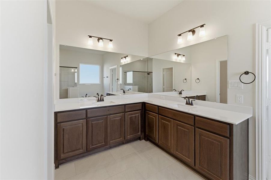 Bathroom featuring double vanity and a shower Bathroom featuring double vanity and a shower