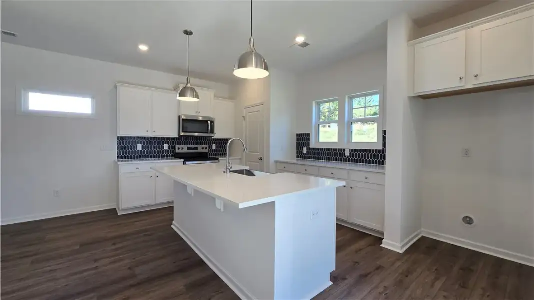 Rich wood flooring anchors the bright kitchen high