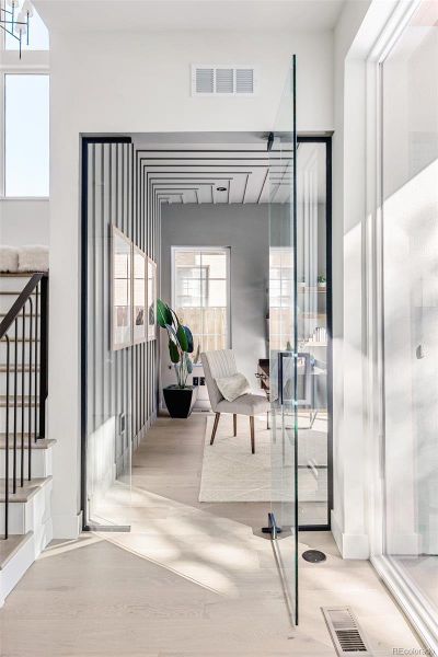 Main-floor office inspires with glass entry, sliding doors to front patio for fresh air and natural light