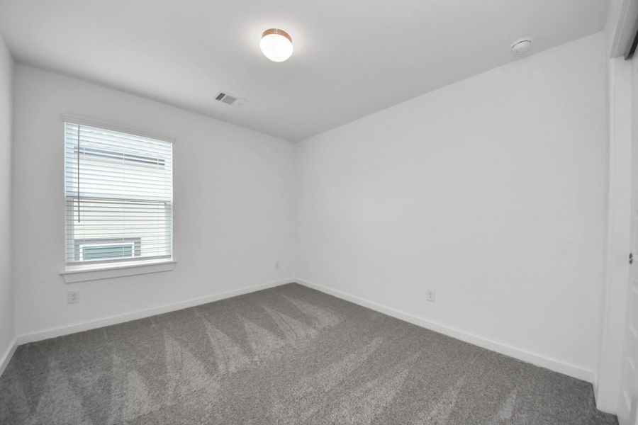 Generously sized secondary bedrooms featuring spacious closets, soft and inviting carpeting underfoot, large windows allowing plenty of natural light, and the added touch of privacy blinds for your personal retreat. Sample photo of completed home with similar floor plan. Actual colors and selections may vary. Generously sized secondary bedrooms featuring spacious closets, soft and inviting carpeting underfoot, large windows allowing plenty of natural light, and the added touch of privacy blinds for your personal retreat. Sample photo of completed home with similar floor plan. Actual colors and selections may vary.